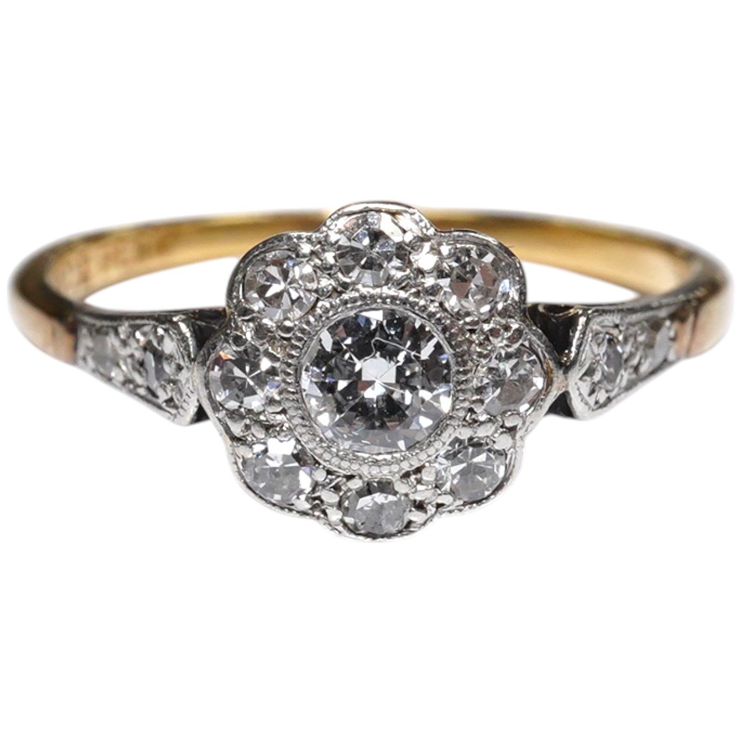 A 1920's 18ct, plat and millegrain set diamond cluster ring, with diamond set shoulders, size N, gross weight 2.4 grams. Condition - fair